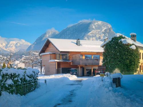 a house covered in snow with mountains in the background at Innradweg in Angath