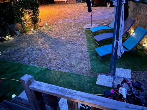 an umbrella and chairs sitting on the grass at Camping 4 étoiles Mobile home 4 à 6 personnes in Aureilhan