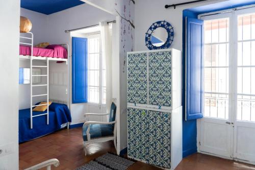 ein Zimmer mit blauen Wänden und ein Zimmer mit Etagenbetten in der Unterkunft Backpacker Al-Katre in Córdoba