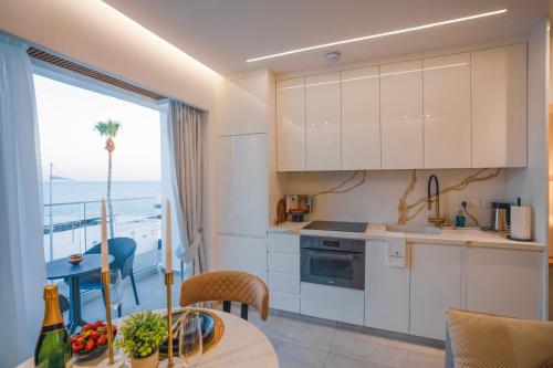eine Küche mit weißen Schränken und Meerblick in der Unterkunft THE OCEAN - Luxury Apartment at the Harbor in Paphos