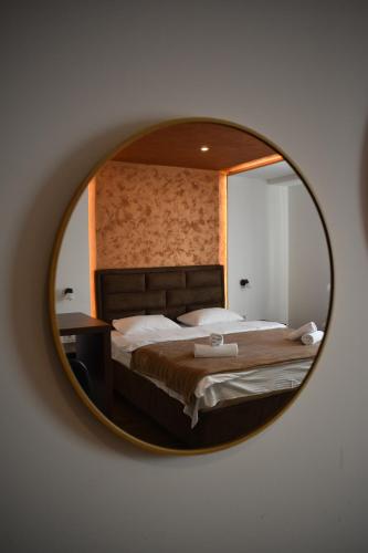 a mirror reflecting a bed in a bedroom at Enigma Bajina Bašta in Bajina Bašta