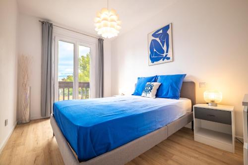 une chambre avec un lit bleu et une fenêtre dans l'établissement Charmant appartement - Box Gourmande -parking -Clim, à Perpignan