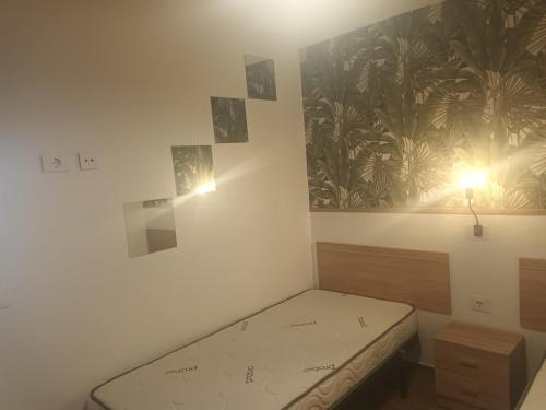 a small bedroom with a bed and a painting on the wall at Lucas beach in Mogán