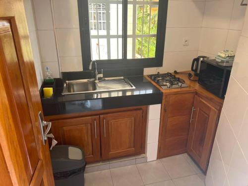 a small kitchen with a sink and a stove at JPN SQUARE Douala in Douala