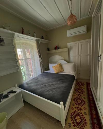 a bedroom with a bed and a window in a room at Cunda Bebekli Pansiyon in Ayvalık