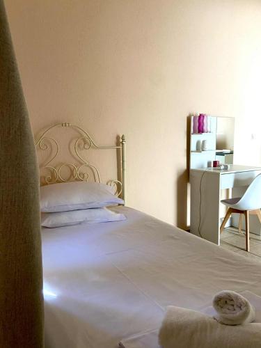 a bedroom with a white bed and a desk at Diamond Maisonette in Kavála