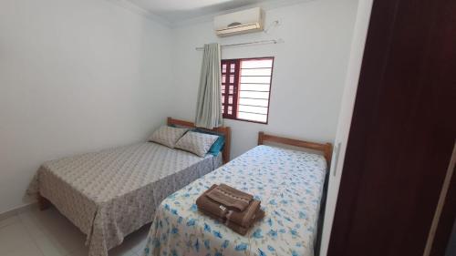 - une chambre avec 2 lits et une valise sur le lit dans l'établissement Casa ROSA in Antunes Maragogi, à Maragogi