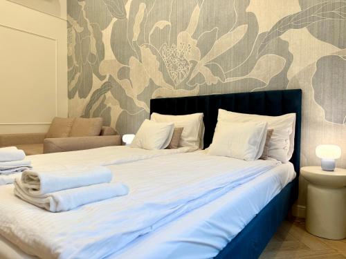 a bedroom with a large bed with towels on it at ROOSEVELTA RESIDENCE Apartments - przy OFF Piotrkowska in Łódź