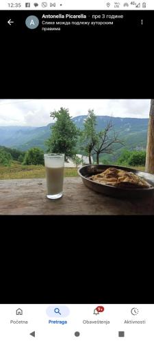 a glass of milk next to a bowl of food at Camp Apartmani Tara in Pljevlja