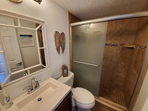 Un baño con ducha, inodoro y lavabo. en Ocean View 2 Bed, 2 bath, Steps to the Beach - Spanish Trace 240, en Coquina Gables