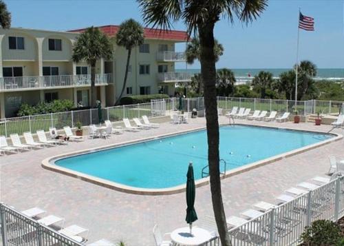 Una piscina con tumbonas y un resort. en Ocean View 2 Bed, 2 bath, Steps to the Beach - Spanish Trace 240, en Coquina Gables