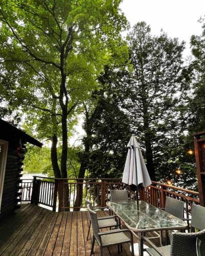 a patio with a table and an umbrella on a deck at The Muskoka Nest in Windermere