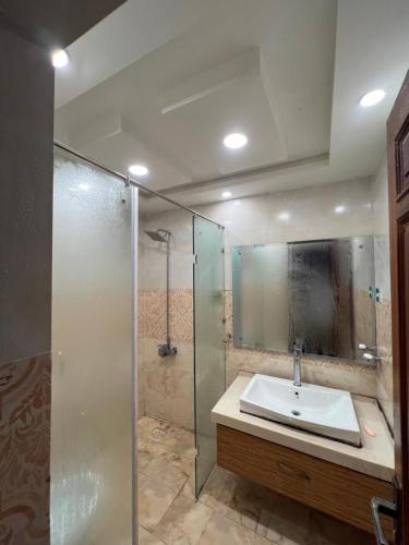 a bathroom with a sink and a glass shower at Cozy 2 Bedrooms Cottage Apartment Changla Gali in Chhāngla Gali