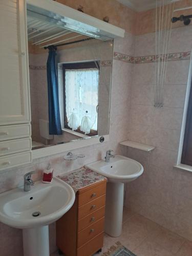 a bathroom with two sinks and a mirror at Casa vacanze Malinini in Savogna