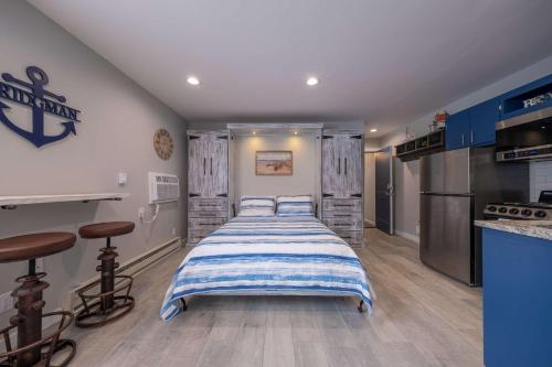 a bedroom with a bed with a blue and white striped blanket at Studio Suite B1 in Bridgman