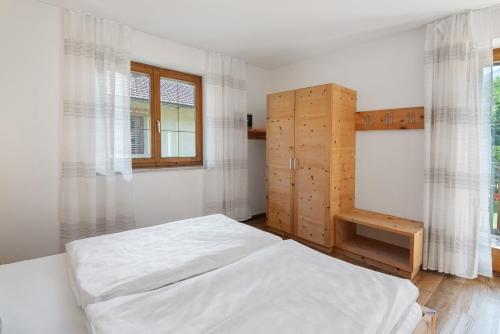 a bedroom with a white bed and a window at New Residence Schnatzhof Schlanders in Silandro