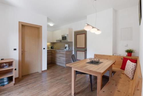 a kitchen and living room with a table and a dining room at New Residence Schnatzhof Schlanders in Silandro