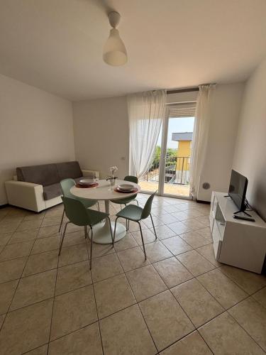 a living room with a table and chairs and a television at Appartamento vicino a Como e Milano in Mozzate