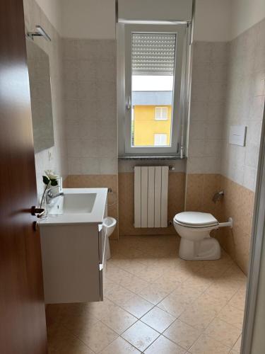 a bathroom with a toilet and a sink and a window at Appartamento vicino a Como e Milano in Mozzate