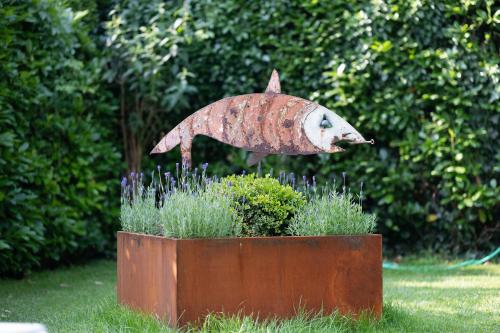 a statue of a fish in a planter in a garden at New Residence Schnatzhof Schlanders in Silandro