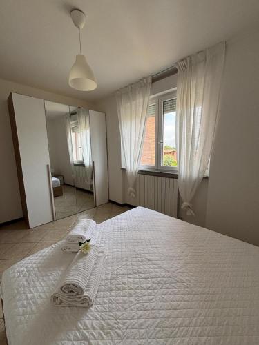 a bedroom with a white bed with two towels on it at Appartamento vicino a Como e Milano in Mozzate