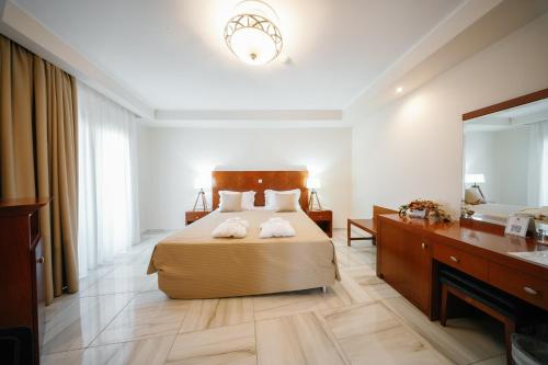 a bedroom with a bed and a dresser and a mirror at Nefeli Hotel in Alexandroupoli