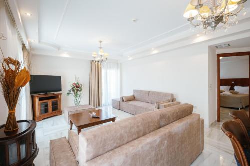 a living room with a couch and a tv at Nefeli Hotel in Alexandroupoli