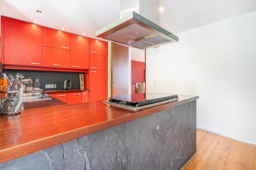 a kitchen with red cabinets and a counter top at Casa Azevinho - Caniçada Gêres in Soengas