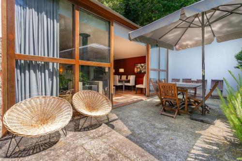 a patio with a table and chairs and an umbrella at Casa Azevinho - Caniçada Gêres in Soengas
