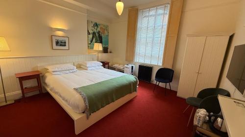 Rúm í herbergi á Kellys Hotel