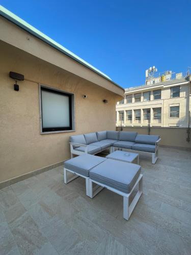 a patio with couches and a tv on a building at B&B Ruggero Settimo - Room & Suite in Palermo
