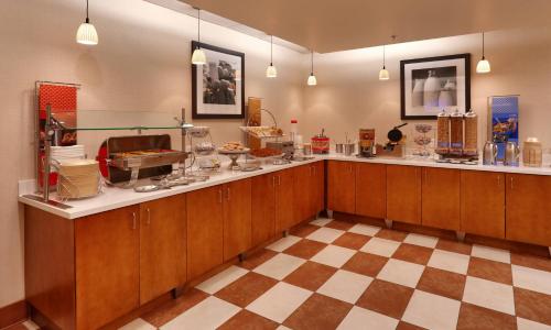 a kitchen with wooden cabinets and a checkered floor at Hampton Inn & Suites Orem/Provo in Orem