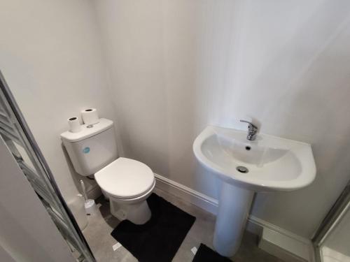 a white bathroom with a toilet and a sink at En-Suite Double-Bedroom in the Heart of Salford Manchester CR3 Perfect for Short Stays in Manchester