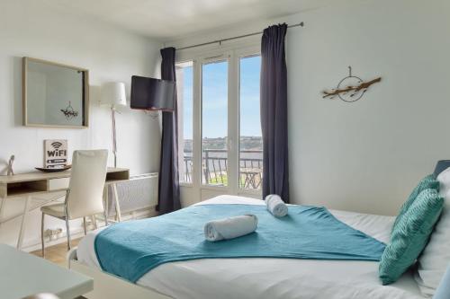a bedroom with a bed with a desk and a window at Le Léon 13 Joli studio avec balcon situé à Dieppe in Dieppe
