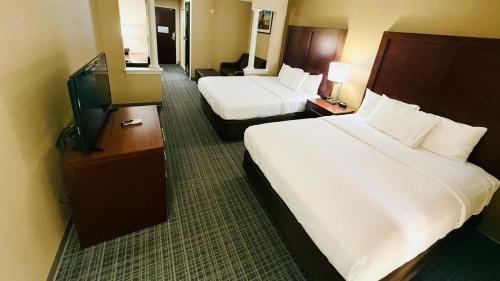 a hotel room with two beds and a flat screen tv at Comfort Inn & Suites Scarborough-Portland in Scarborough