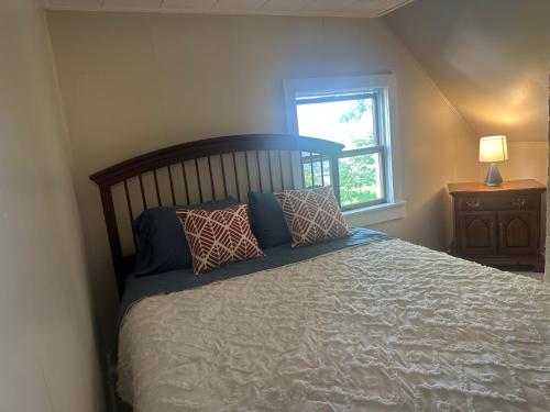 a bedroom with a bed with pillows and a window at Sawyer Cove Cottage in Jonesport
