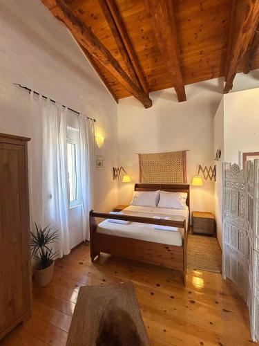 a bedroom with a bed in a room with wooden ceilings at Le Havre in Païdhokhórion