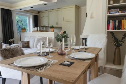 a dining room table with plates and wine glasses at Willkommen in Ihrem sonnigen Gartenapartment in Kitzbühel