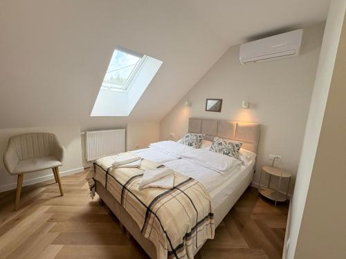 a bedroom with a bed and a skylight at Kwietny Stoczek 70 in Białowieża