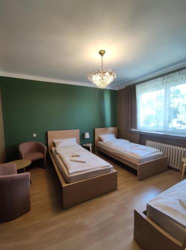 a bedroom with two beds and a chandelier at Villa For You in Oświęcim