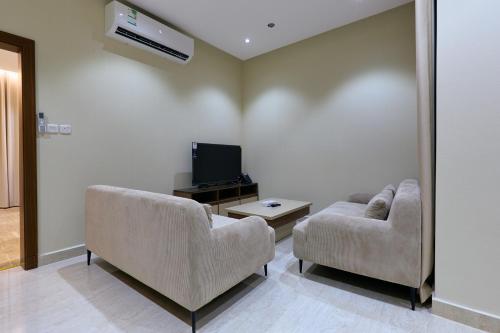 a living room with two couches and a tv at شقق منازل بلقيس للشقق المخدومة الآثير in Hail