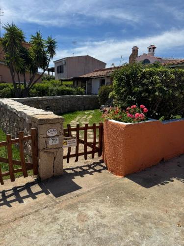 a wooden fence and a bench next to some flowers at Lupo 1 in Cannigione