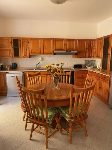 a kitchen with a wooden table with a vase of flowers on it at Casa Vè in Sperlonga