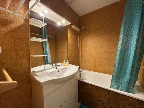 une salle de bain avec un lavabo, une baignoire et un miroir dans l'établissement Studio 4 pers avec balcon, proche télécabine, télé, Wi-Fi, casier à skis - Morillon - FR-1-642-30, à Morillon