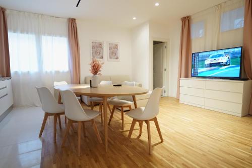 a dining room with a table and chairs and a tv at La Marina Case Vacanze in Augusta
