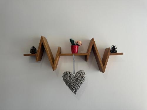 a wooden heart on a wall with a plant at Appartement lumineux avec terrasse & Wifi à Verchaix - FR-1-642-82 in Verchaix
