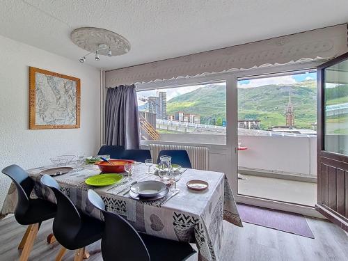 une salle à manger avec une table et des chaises et une fenêtre dans l'établissement Appartement confortable Centre station Balcon - FR-1-344-922, aux Menuires