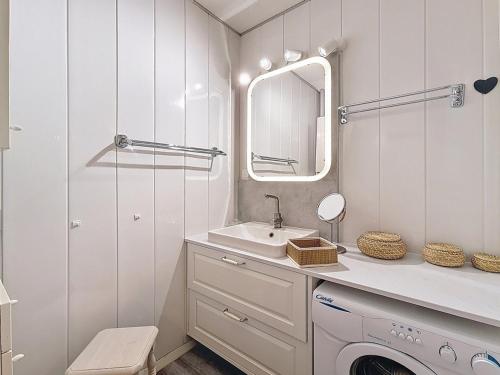 une salle de bain blanche avec un lavabo et un miroir dans l'établissement Appartement confortable Centre station Balcon - FR-1-344-922, aux Menuires