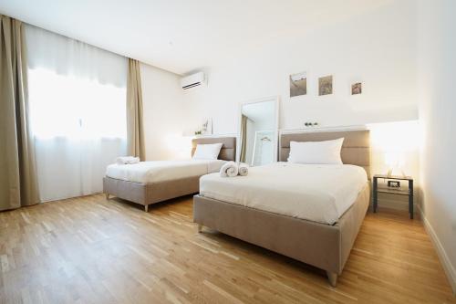 a bedroom with two beds and a mirror at La Marina Case Vacanze in Augusta