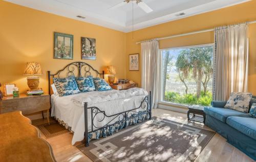 a bedroom with a bed and a couch and a window at 159 Ocean Creek in Fripp Island
